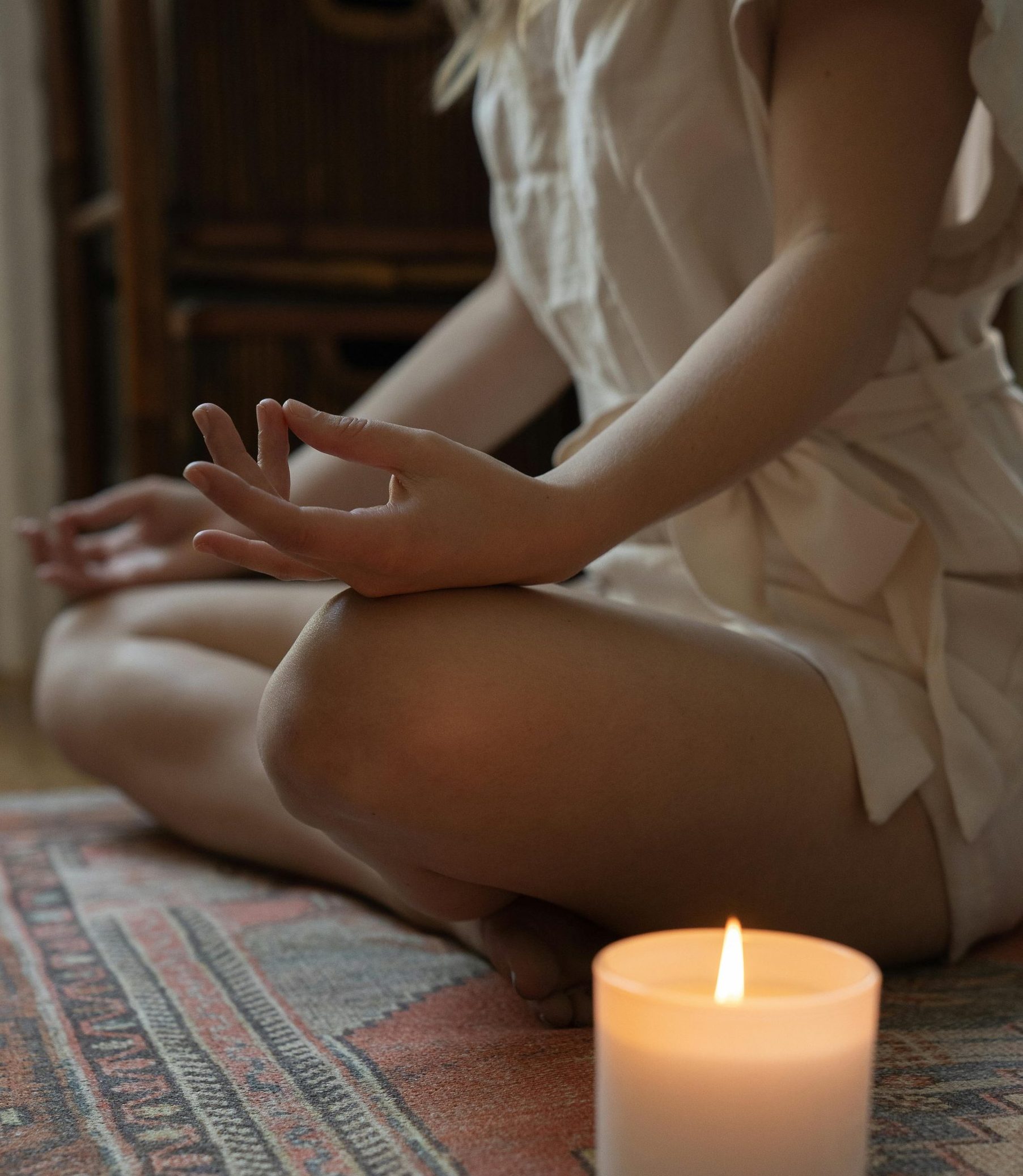 Experience tranquility with a lit candle and meditative pose, ideal for mindfulness practices.